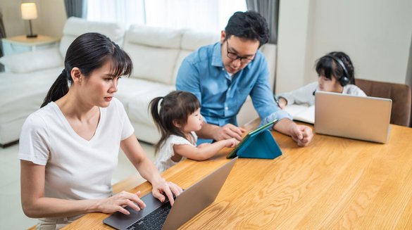 Remote-working parents assisting their young daughter with online learning at home.jpg