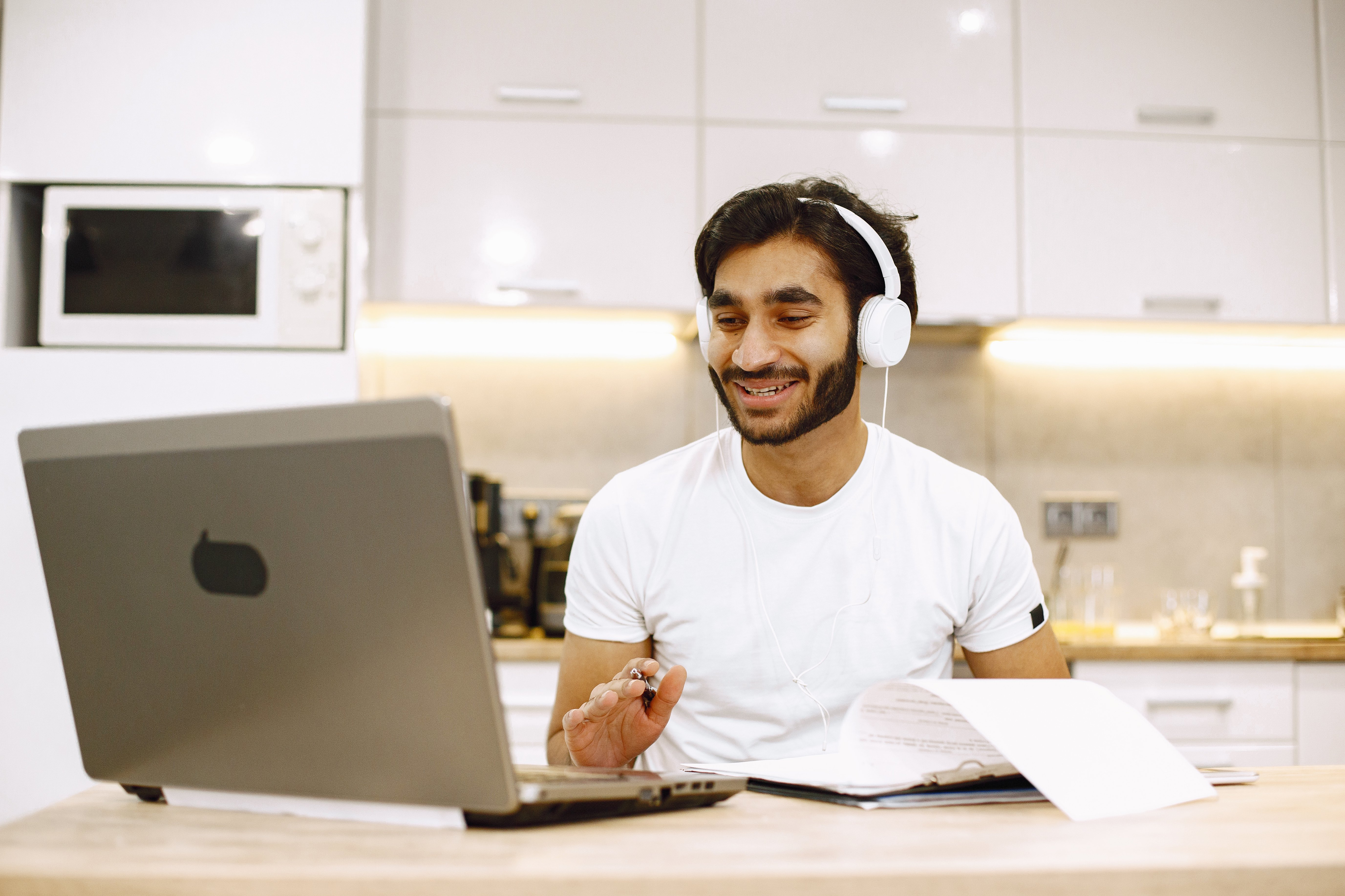 arabic-man-watching-online-webinar-sitting-kitchen-with-computer-enjoying-distance-learning.jpg