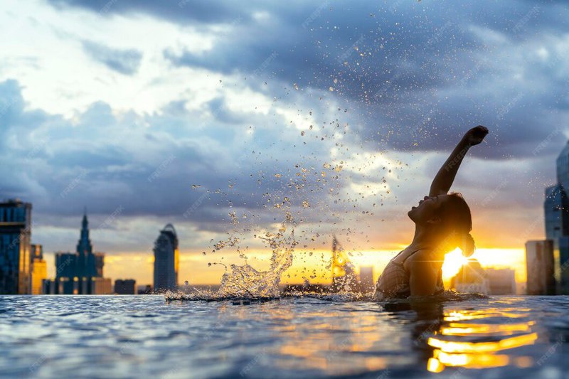 black-silhouette-asian-woman-splash-water-summer-vacation-holiday-relaxing-infinity-swimming-pool-with-blue-sea-sunset-view-with-high-rise-skyscape-urban-downtown-healthy-happiness-lifestyle_609648-992.jpg
