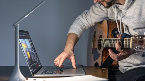 man-with-guitar-front-laptop-late-hour-learns-play.jpg