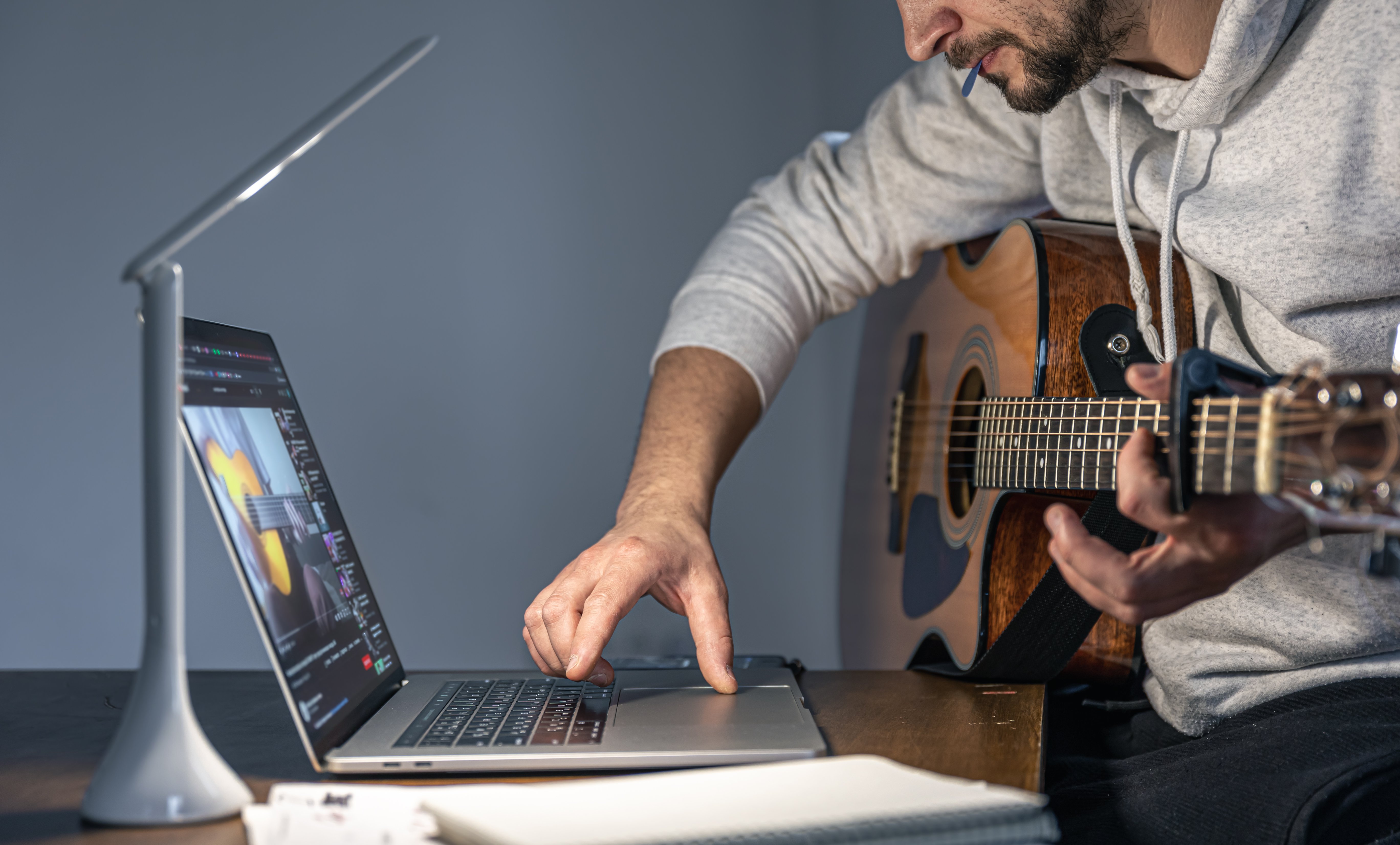 man-with-guitar-front-laptop-late-hour-learns-play.jpg
