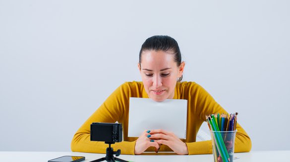smiling-blogger-girl-is-showing-mockup-idea-with-paper-white-background.jpg